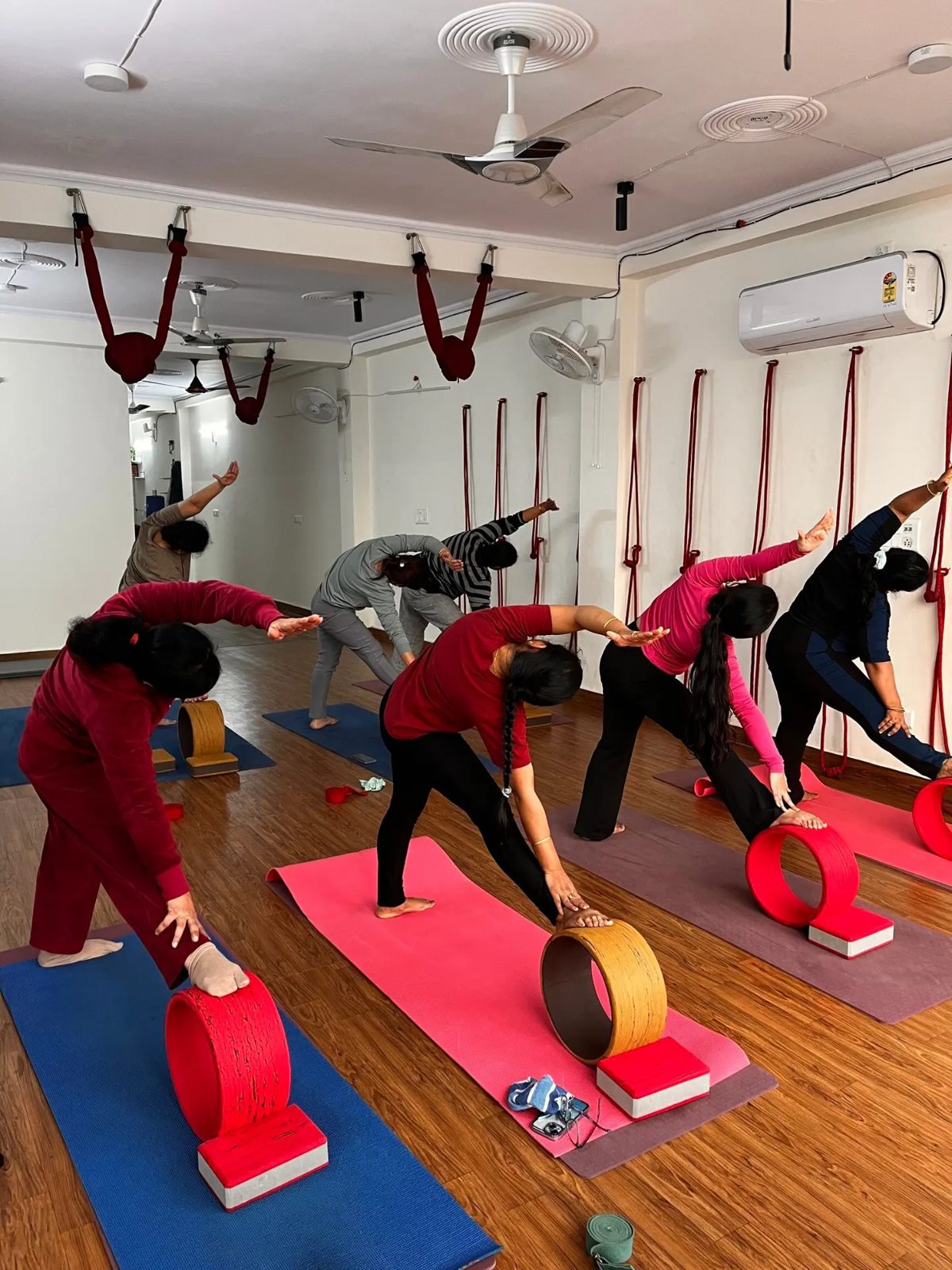 Group class using yoga wheels and blocks during a side-bend sequence at Veda Yoga Studio